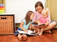 Eine Frau liest zwei Kindern vor