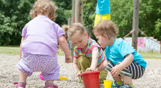 Kinder spielen im Sand